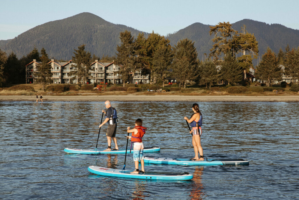 A family enjoys stand-up paddle boarding in front of the Best Western Plus Tin Wis Resort on Mackenzie Beach in Tofino, British Columbia, on October 2, 2022. Melissa Renwick/ZenSeekers